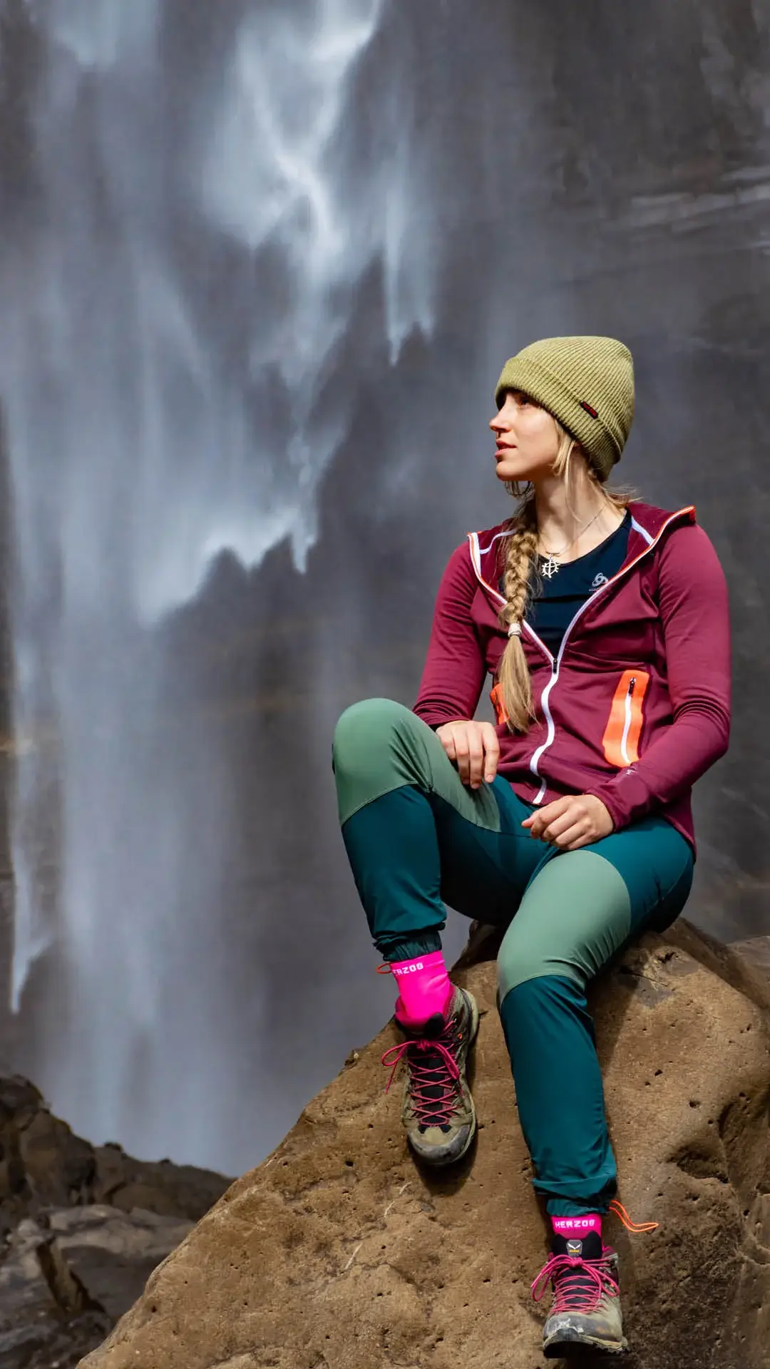 DSC_0840 1080 x 1920 Woman sits on a stone in front of a waterfall.