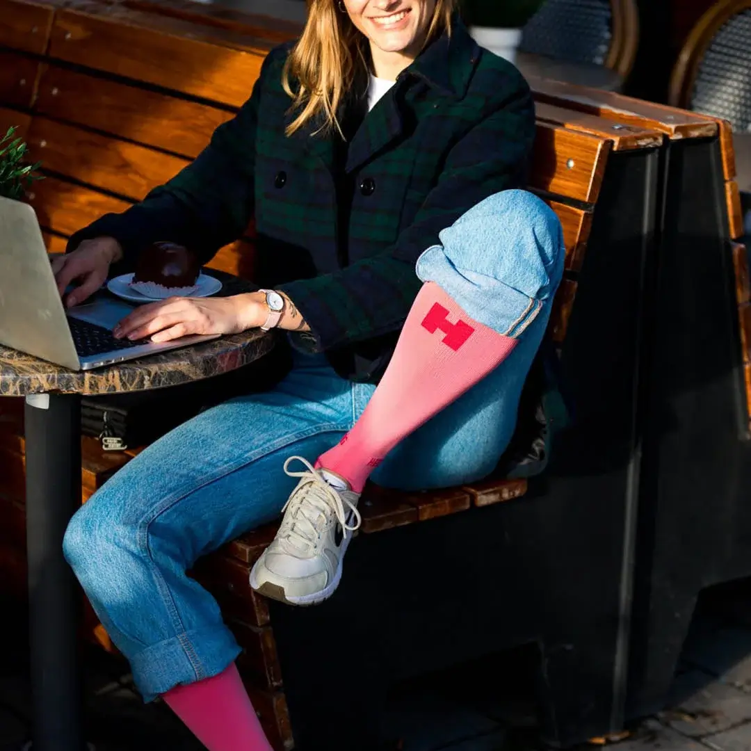 Website Lifestyle shoot bosche bol Vrouw zit op het terras met laptop. Ze draagt de Support Compressiekous.