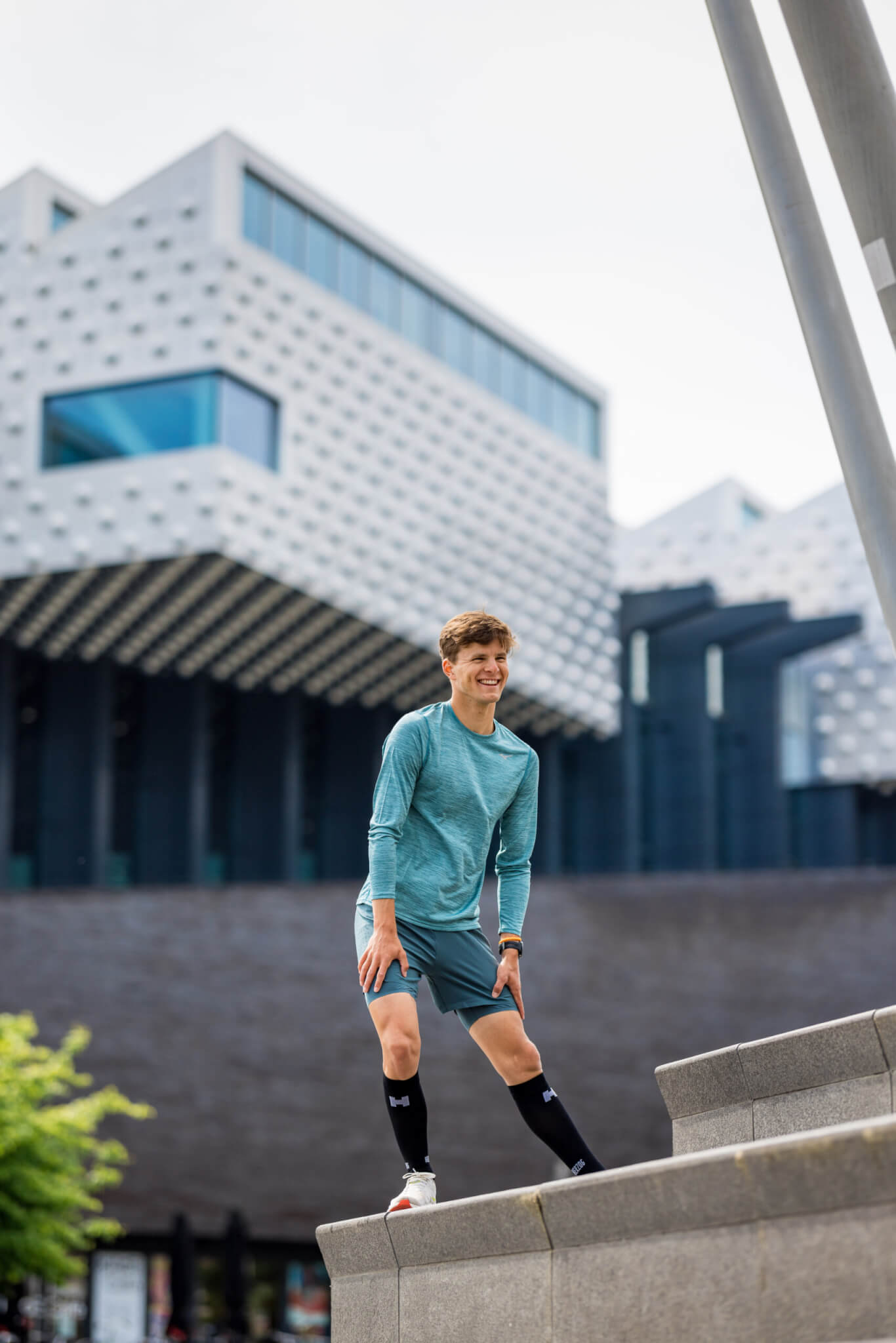 Jongen stretcht scheenbeen en kuiten op trap om shin splints te voorkomen